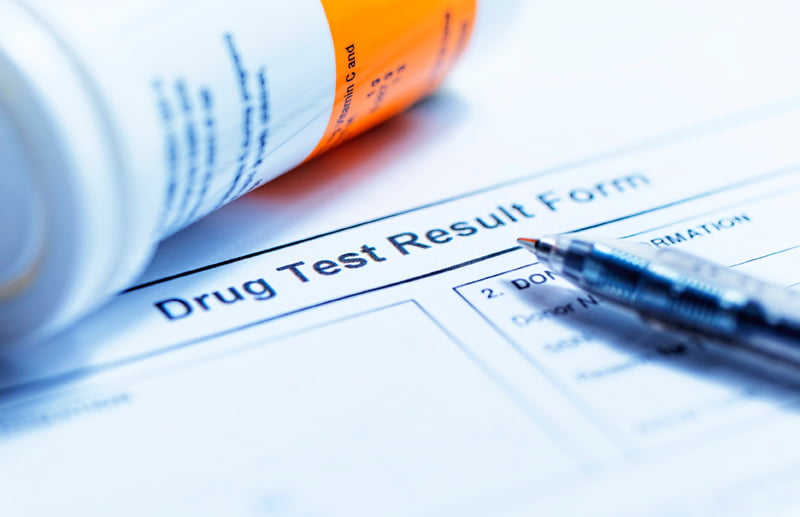 Drug Test Results Form with a bottle and pen on top of the sheet